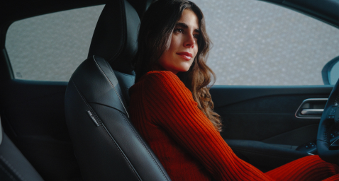 Pasitikinti ir besi&scaron;ypsanti moteris vairuotojo vietoje